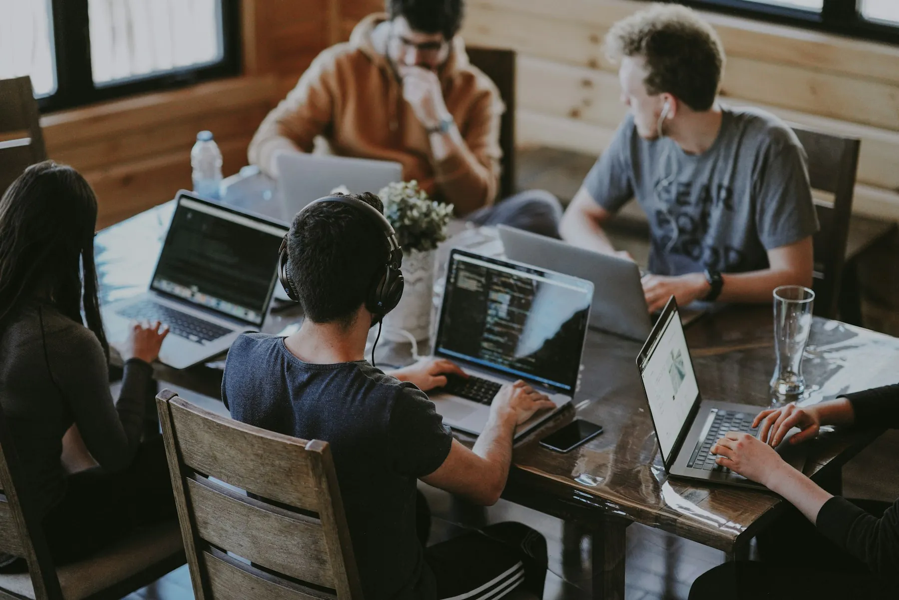 The Rayonex team working together around a table with laptops